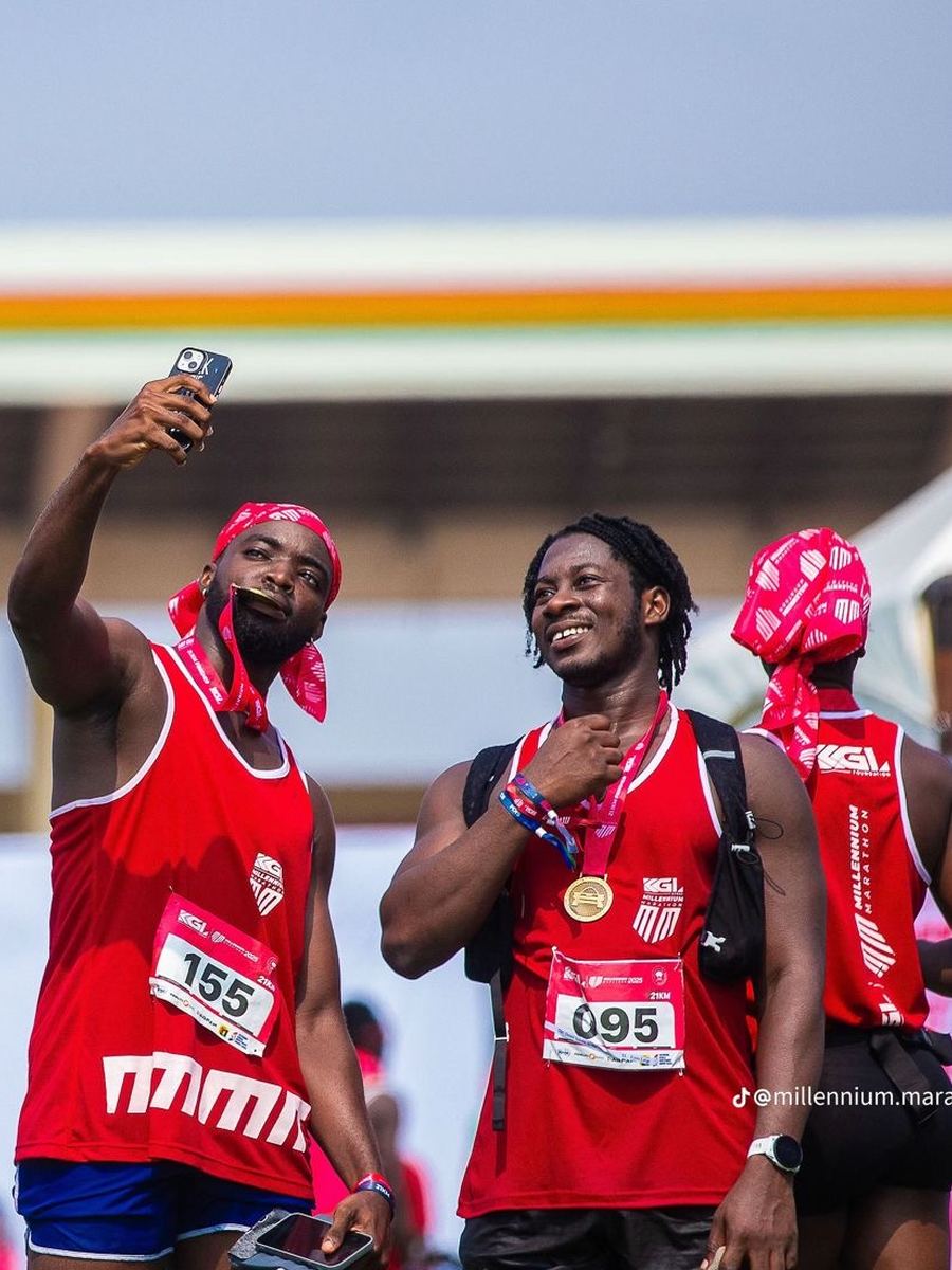 Two finishers walking back with their medals and their shoes in hand