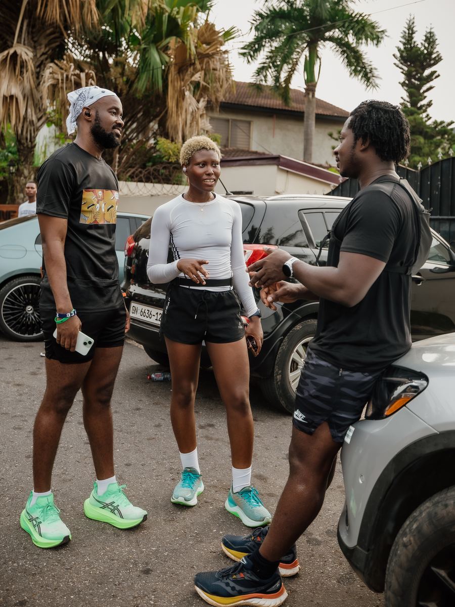 Three runners talking beside the cars before a morning run